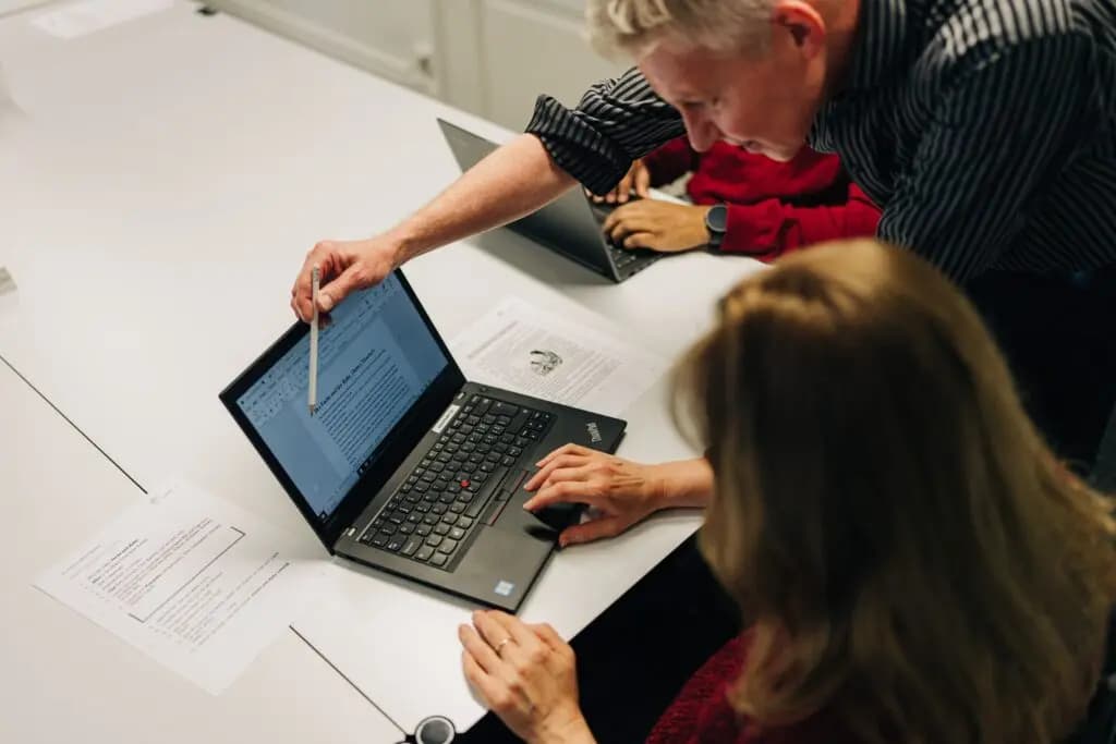 Das ist ein Foto unseres Kursleiters, der einem Teilnehmenden einen Computerkurs gibt.